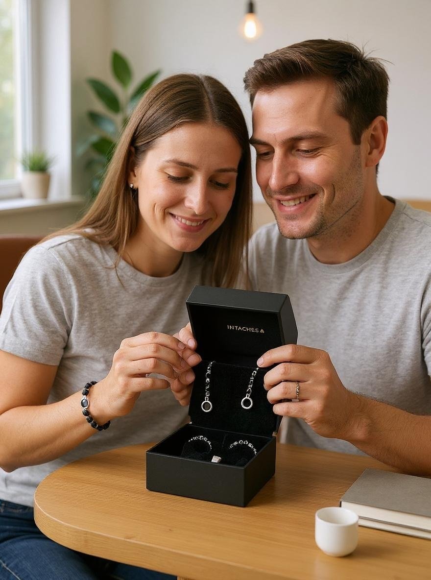 Paar packt gemeinsam die Geschenkbox mit zwei Perlenarmbändern aus